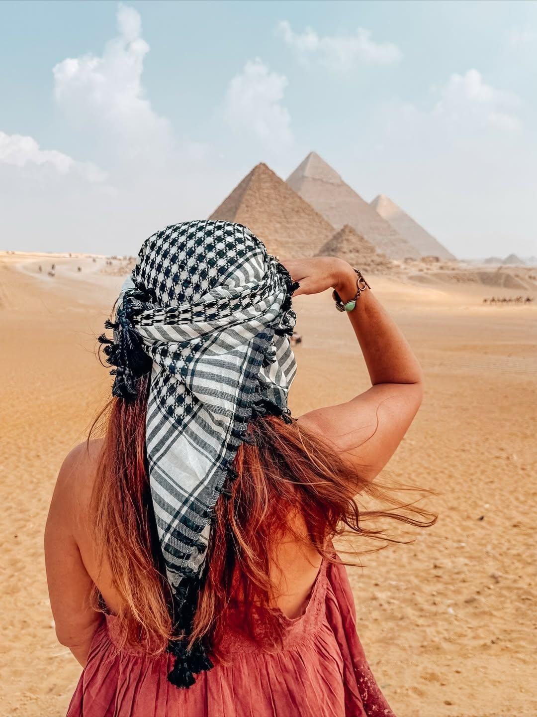 Female tourist standing at the panoramic viewpoint of the Giza Pyramids and Great Sphinx during a private Cairo day trip, capturing Egypt