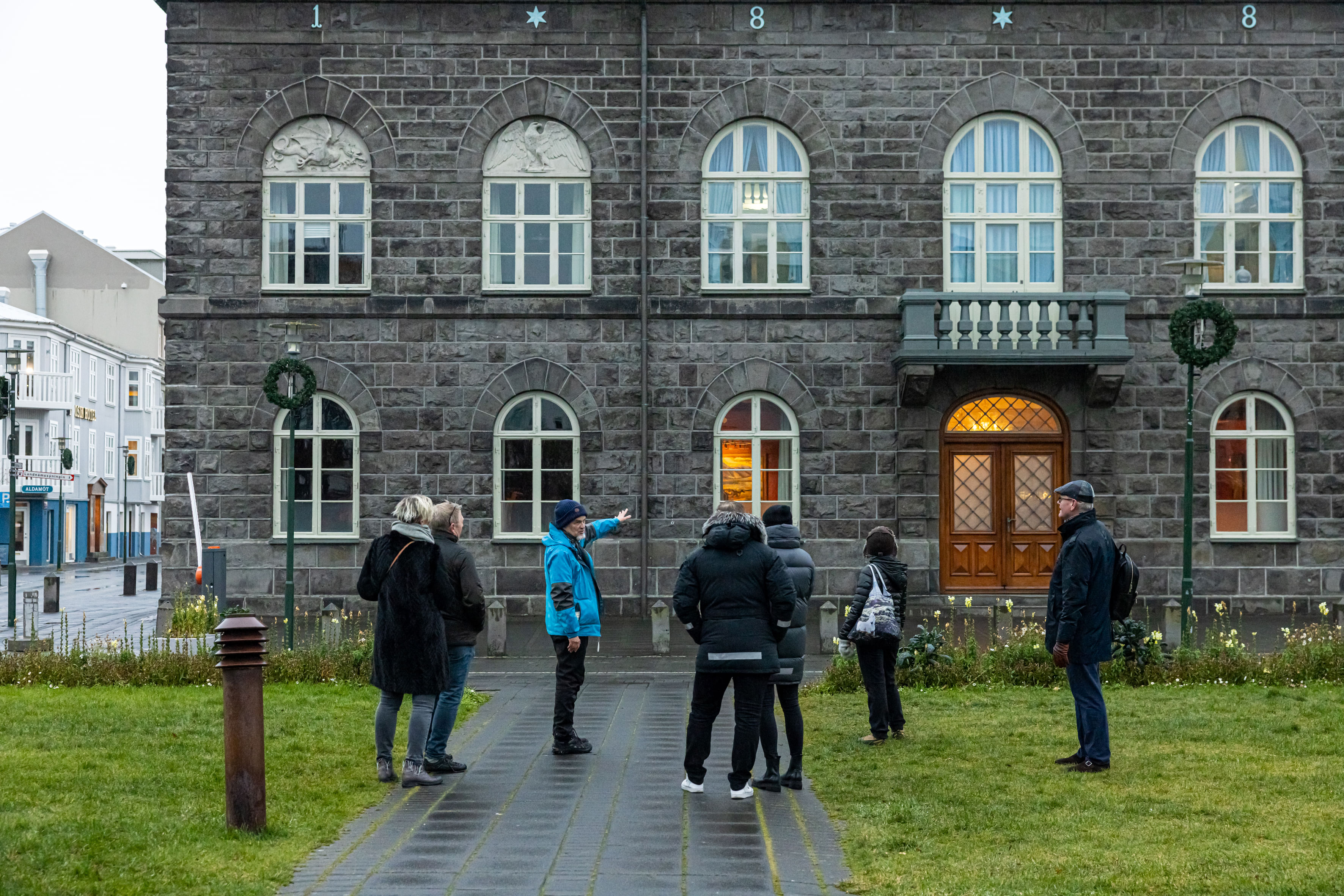 A guide from Your Friend in Reykjavik explaining the history of the Icelandic Parliament Building to a group of guests.
