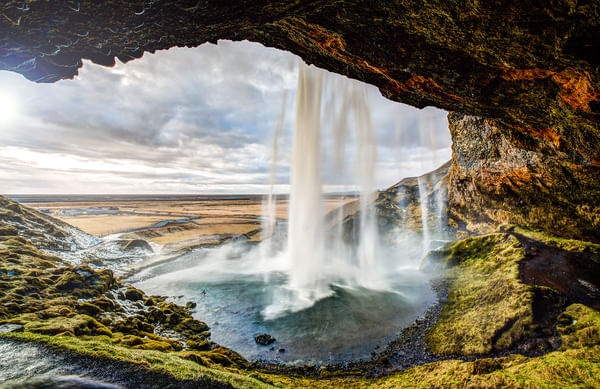 Taking the secret path behind the waterfall of Seljalandsfoss waterfall