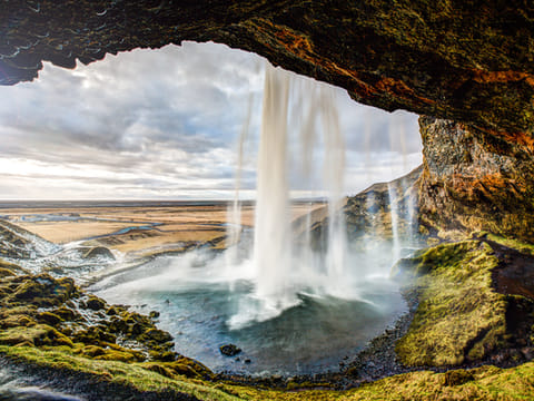 Taking the secret path behind the waterfall of Seljalandsfoss waterfall