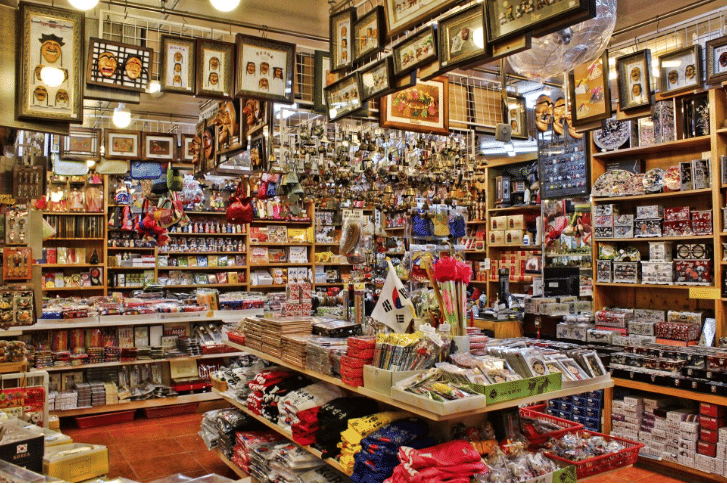 Various souvenirs, trinkets, and decorations on shelves inside Gukje Market.