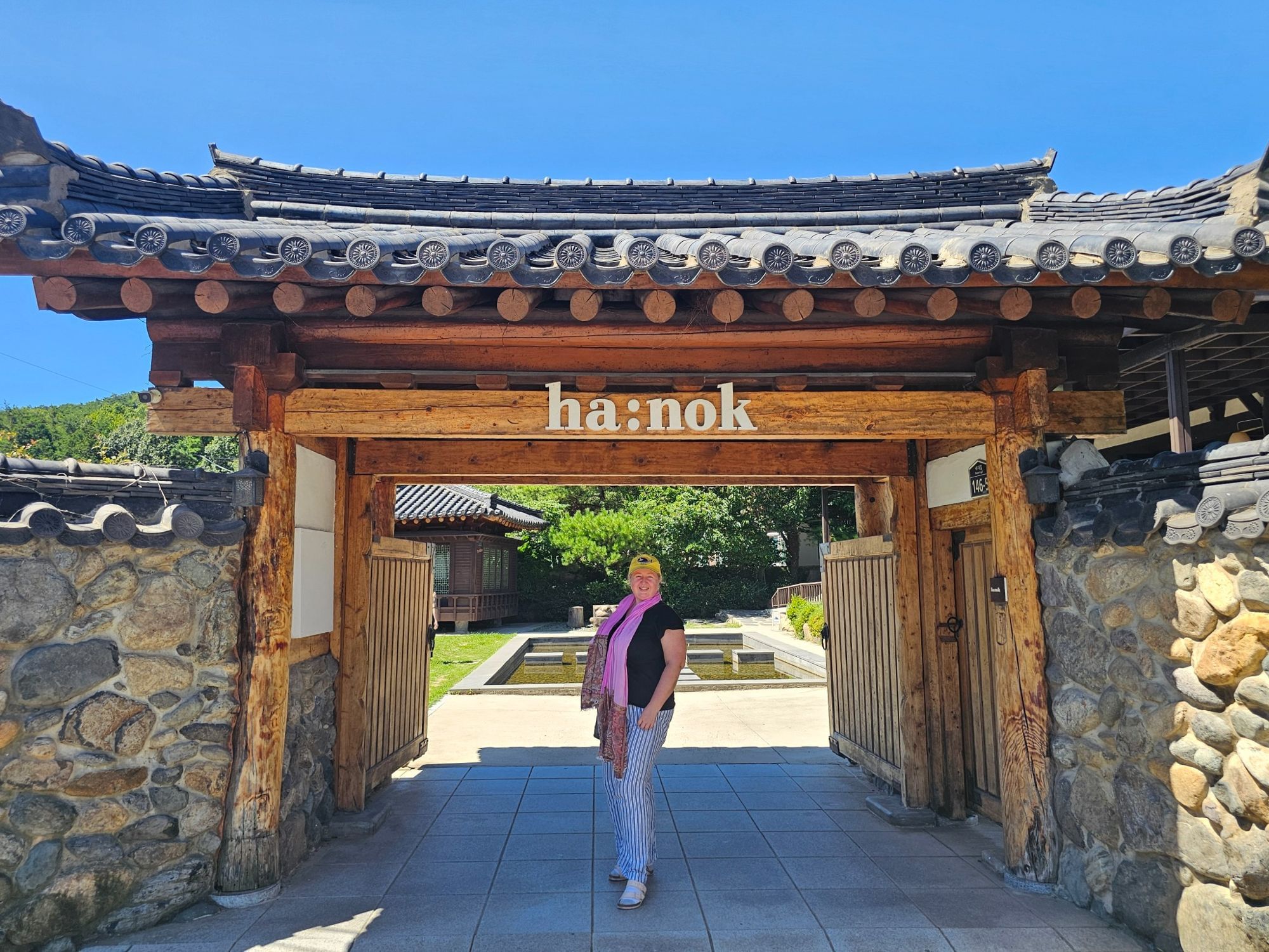 Front view of a wooden hanok café gate with Korean roof tiles.