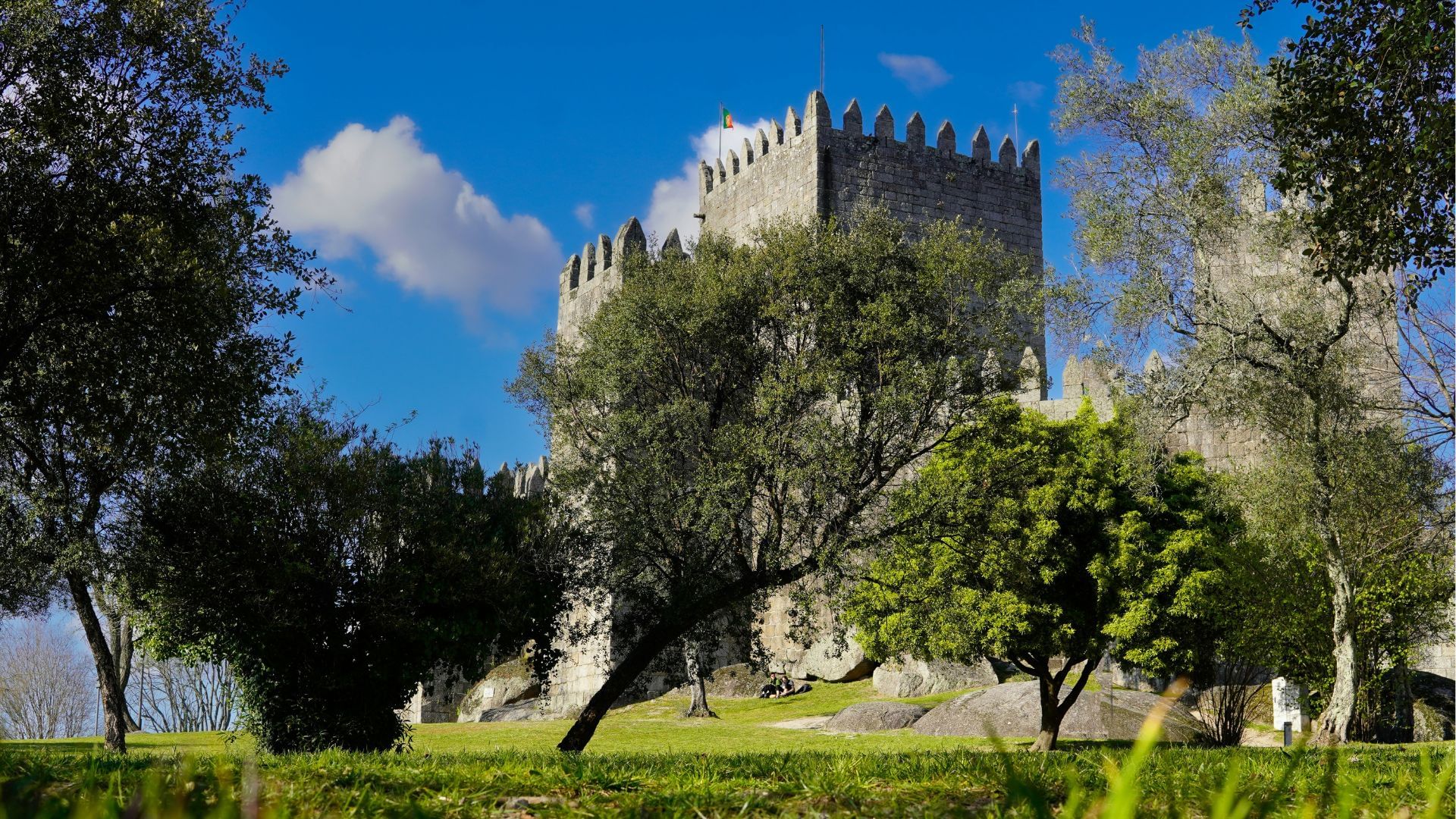 Image of Guimarães Castle surrounded by green vegetation, part of Cooltour Oporto's Braga & Guimaraes Tour