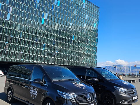 Two Tour Vehicles from Your Friend in Reykjavik parked in front of the Harpa Concert Hall in Reykjavik