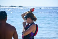 Woman receiving snorkeling safety instructions from guide Los Cabos ocean tour