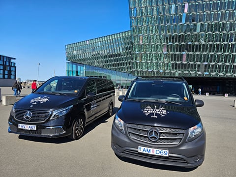 Two Tour Vehicles from Your Friend in Reykjavik parked in front of the Harpa Concert Hall in Reykjavik