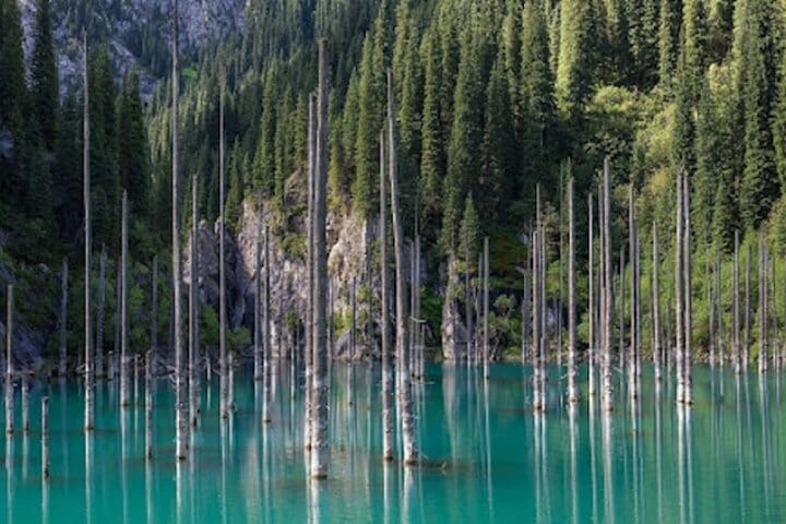 Mountain lake with underwater forest and clear blue water near Saty village.
