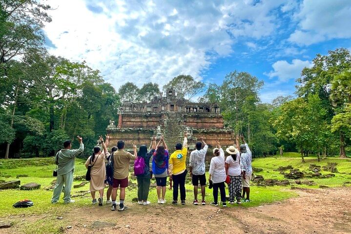 Tour group standing in front of Angkor Wat temple on a guided sunset tour in Cambodia