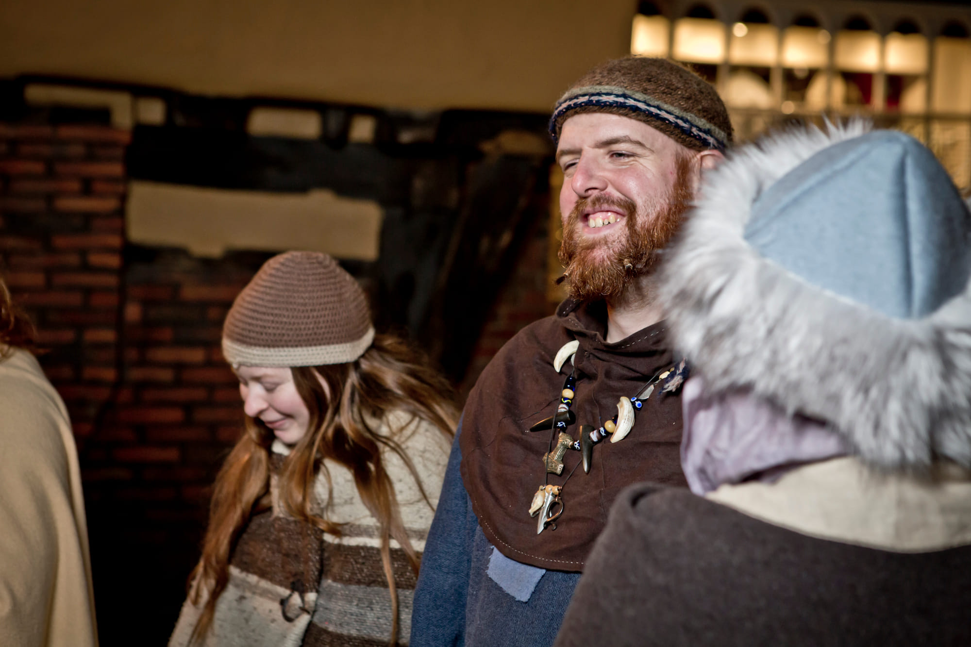 A happy Viking warrior and legend, Ragnar, flanked by two viking ladies with a broad grin.