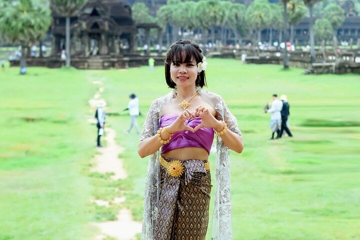 Traveler wearing traditional Khmer dress in front of Angkor Wat during a cultural photo tour