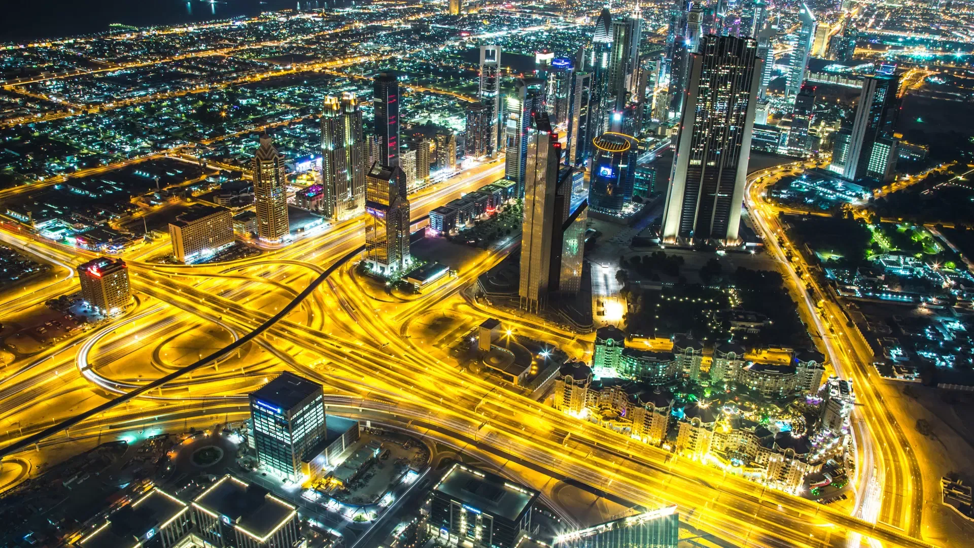 Golden night view of the highway interchange and the towers of Sheikh Zayed Road spreading out beneath the deck at Burj Khalifa