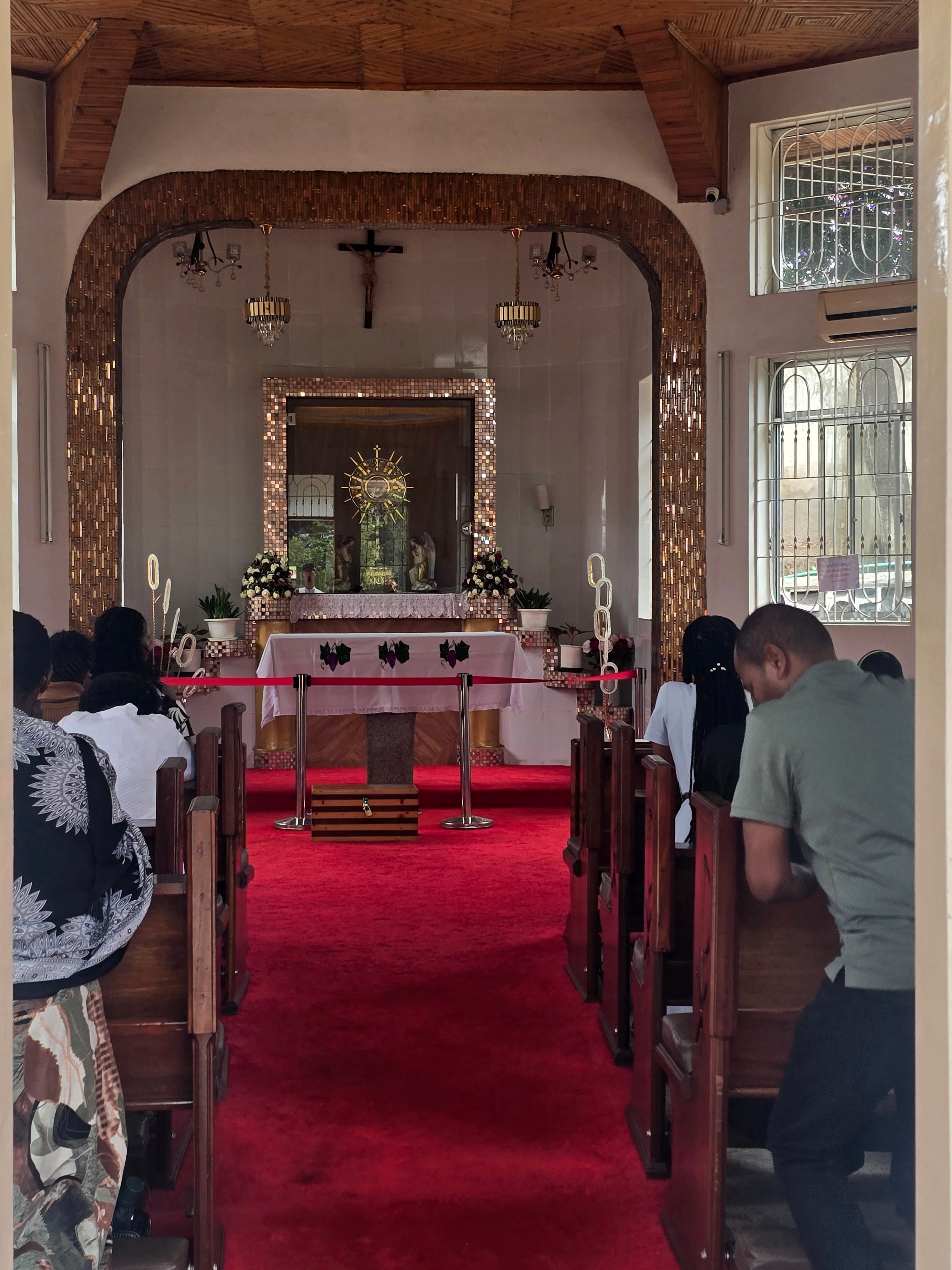 A central view looking down the aisle with a red carpet leading toward the church altar and framed archway.