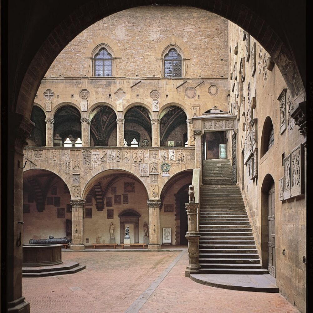 Internal courtyard of the Bargello Museum with its decorated walls, staircase and well