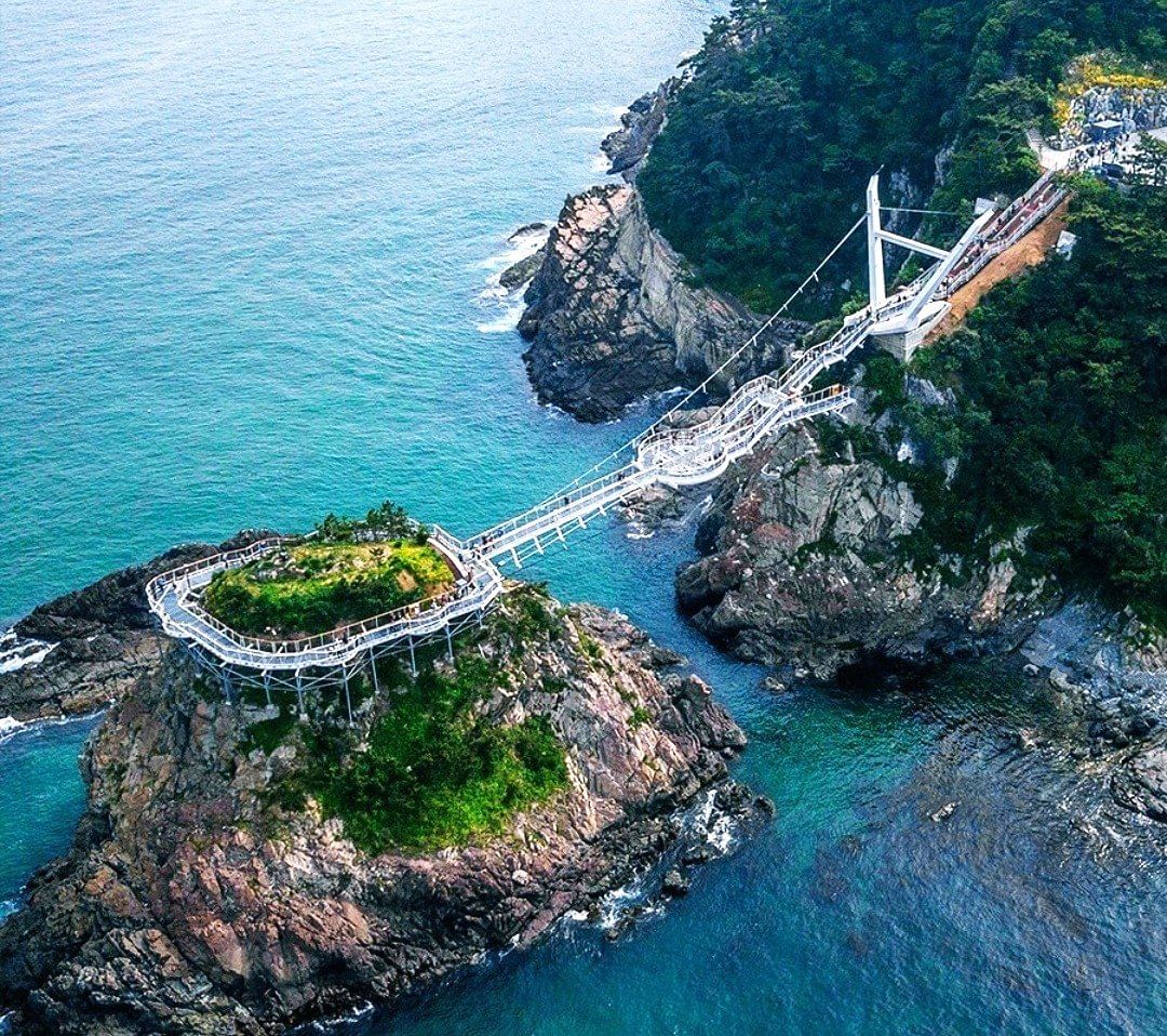 Aerial view of the Songdo Yonggung Cloud Bridge stretching along the rocky coastline.