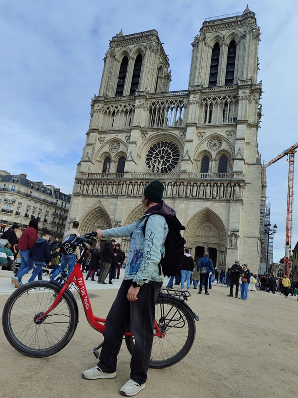 A rider with a red bike in front of Notre-Dame Cathedral