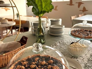 Cake displayed on a table with rhubarb leaf decoration in the background