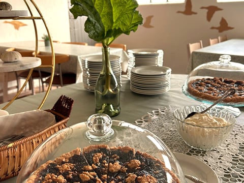 Cake displayed on a table with rhubarb leaf decoration in the background