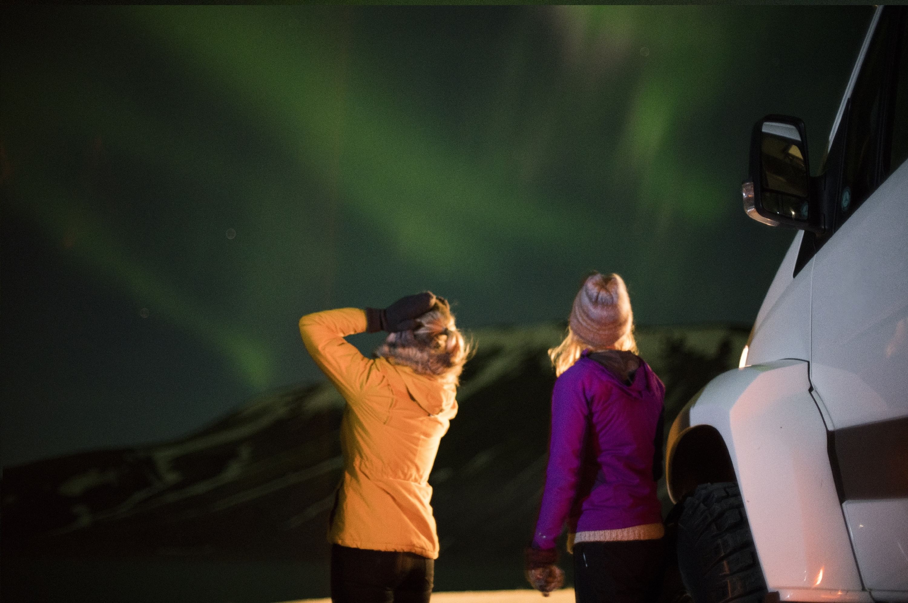 Women enjoying the Northern lights during Northern lights jeep tour in Iceland