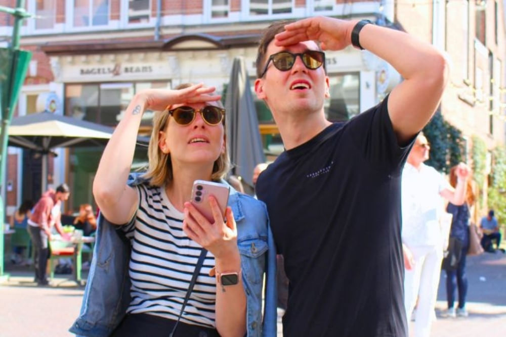 Tourists playing the Qugato outside escape game City Detective.