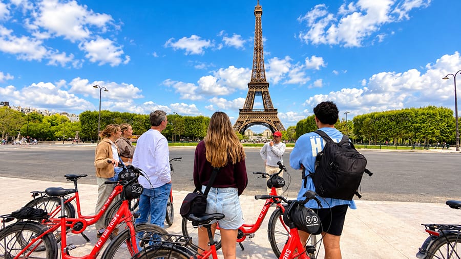 Riders with red bikes in front of the Eiffel Tower