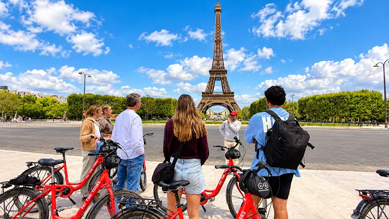 A tour group with red bikes looking at the Eiffel Tower
