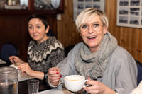 A guest smiling while enjoying a cup of Icelandic soup