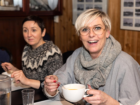 A guest smiling while enjoying a cup of Icelandic soup