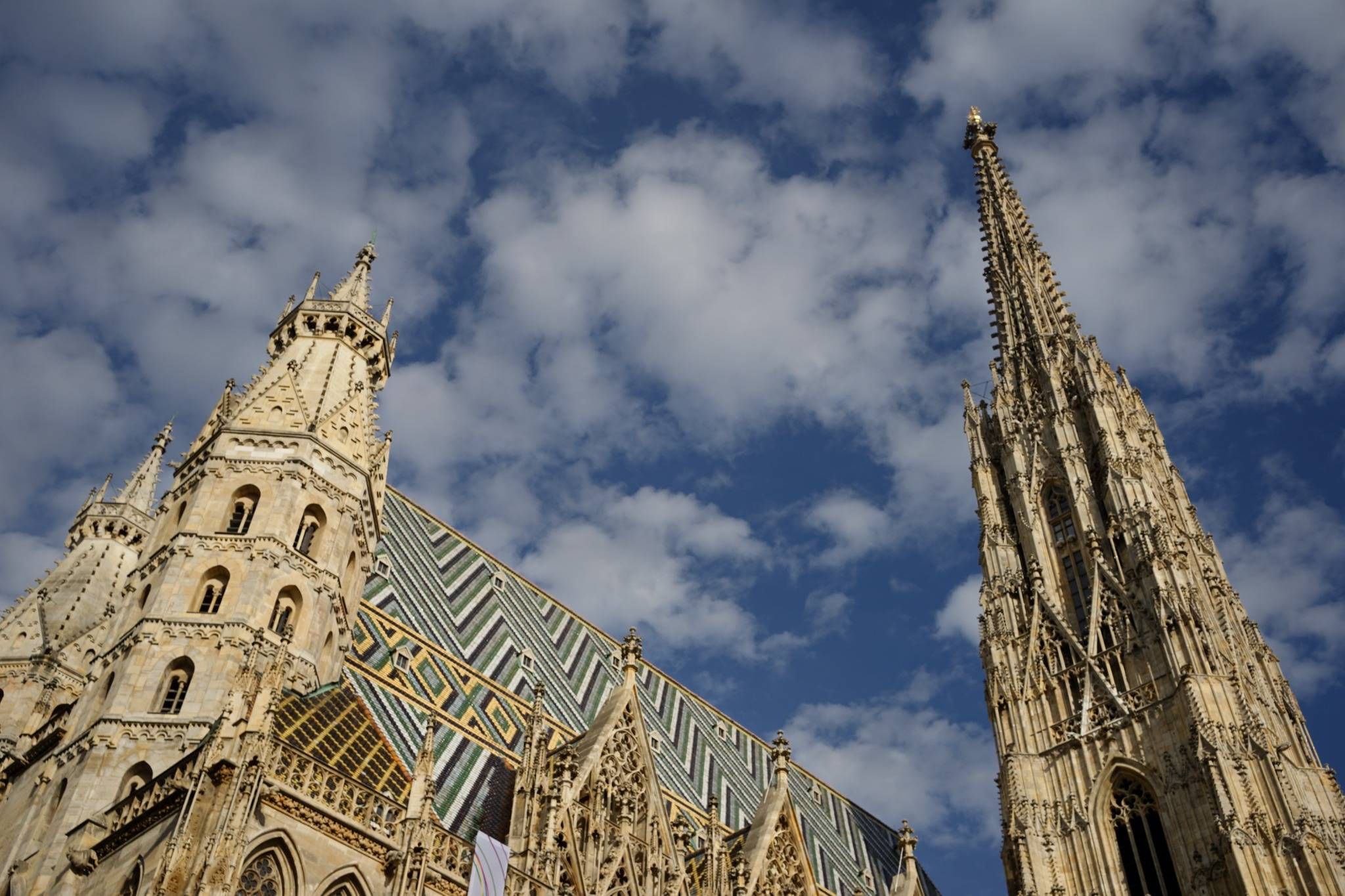 Gothic towers and tiled roof of St. Stephen’s Cathedral against blue sky