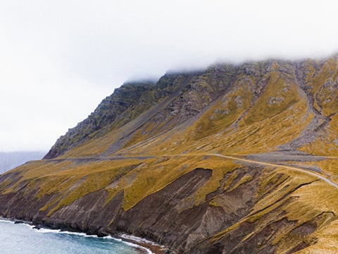 Dramatic cliffs and ocean along the Trollaskagi Coast