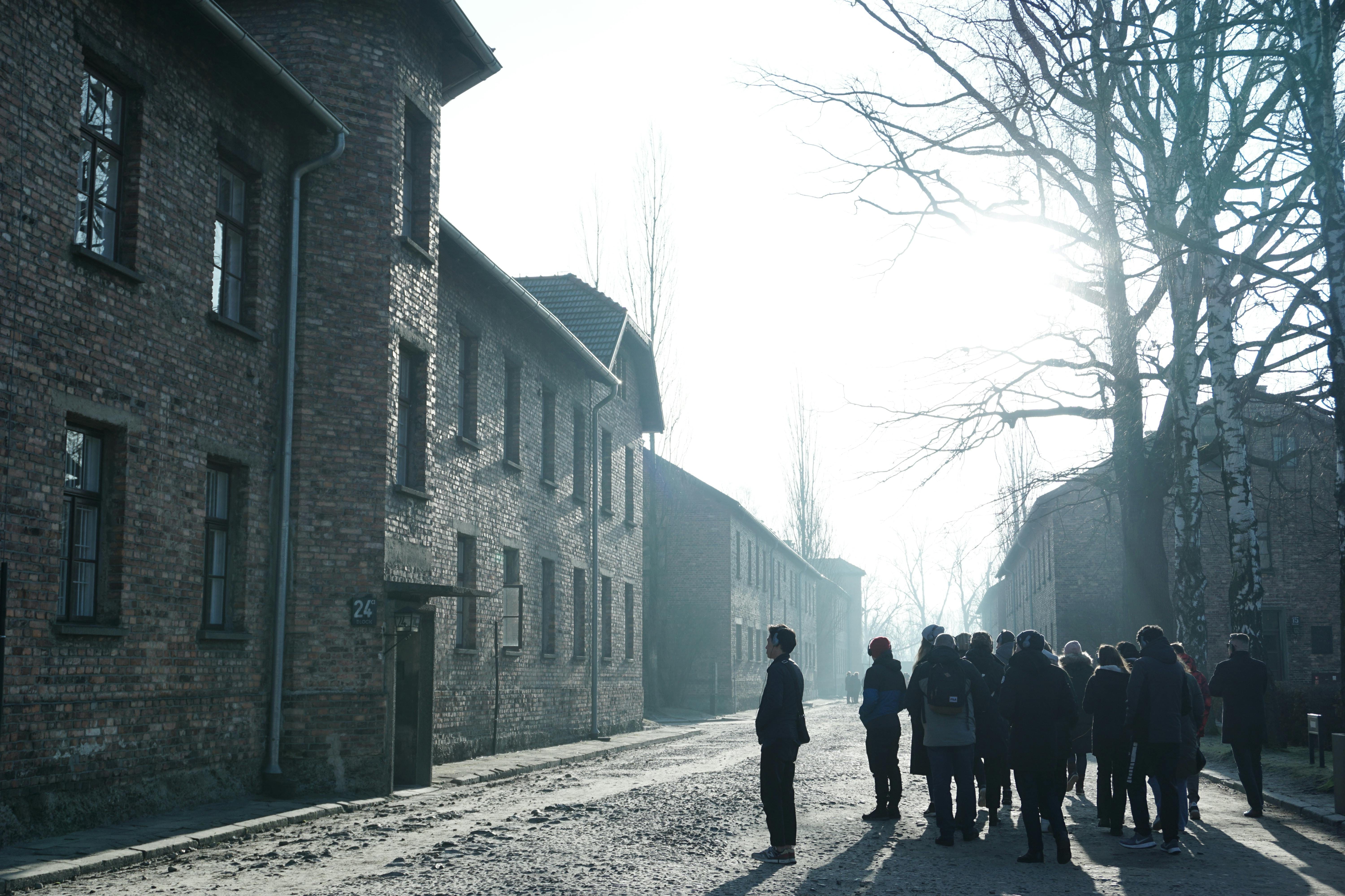 Visitors walking along the barracks at Auschwitz I Memorial and Museum, Oświęcim, Poland