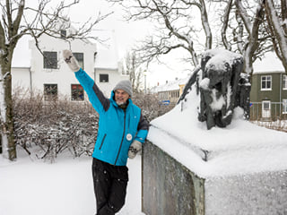 A guide from Your Friend in Reykjavik sharing a story about cats in front of a monument.