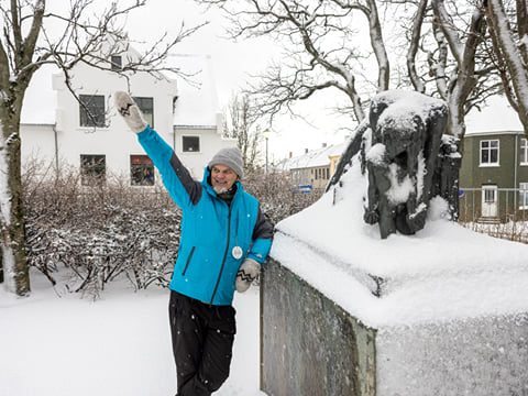 A guide from Your Friend in Reykjavik sharing a story about cats in front of a monument.