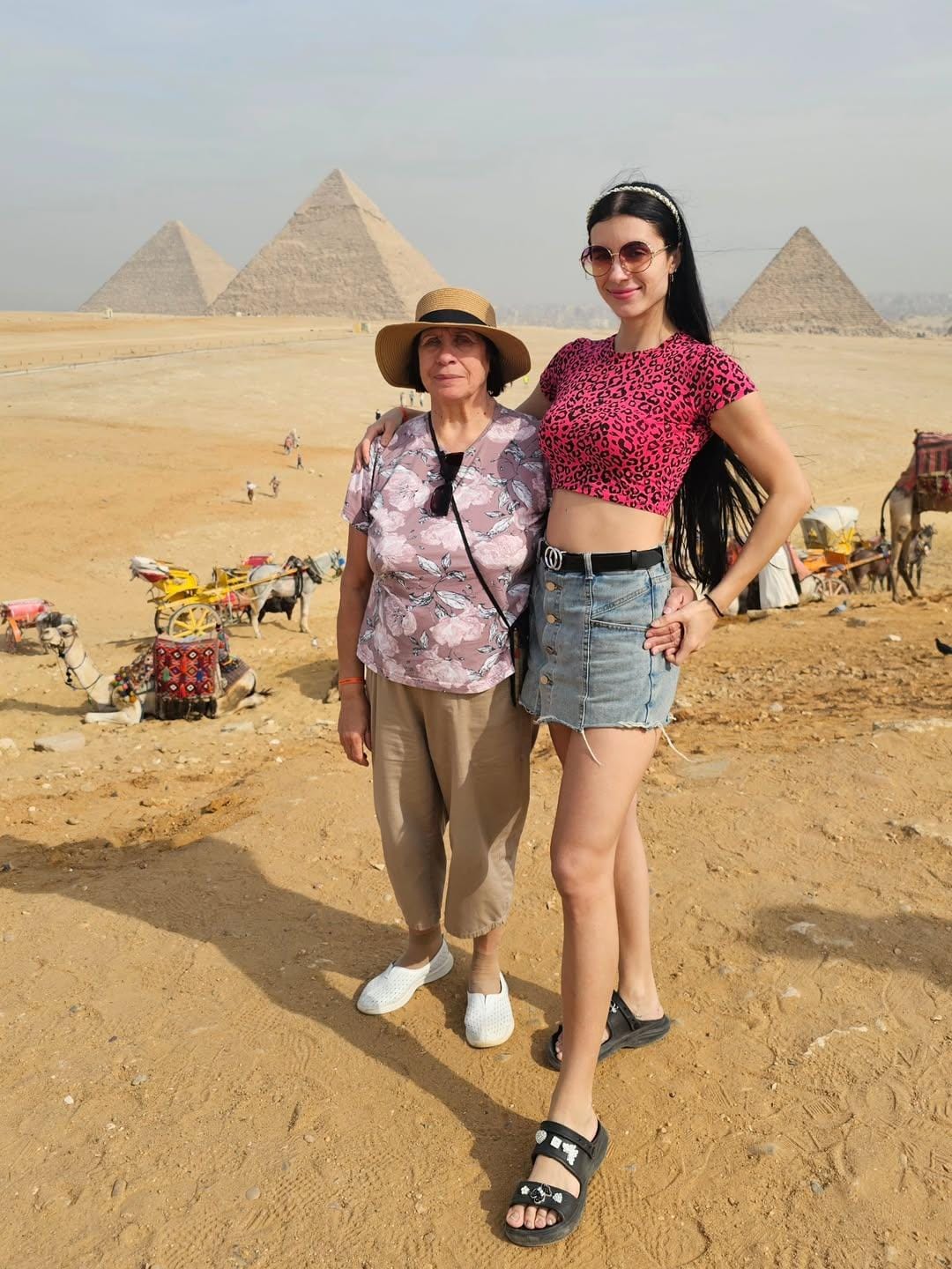 ourists smiling and posing at the Giza Plateau panorama, with the Great Pyramid of Khufu, Khafre, and Menkaure in the background during a pr