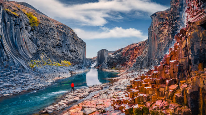 Towering basalt columns lining the vibrant blue waters of Stuðlagil Canyon