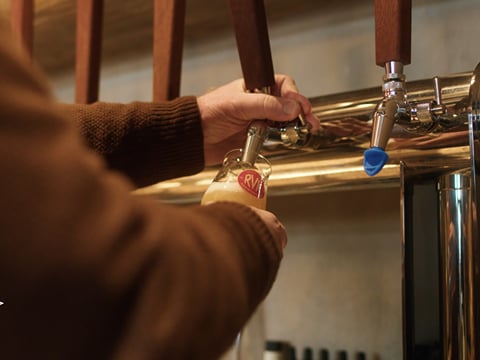 A bartender drawing a beer from a tap