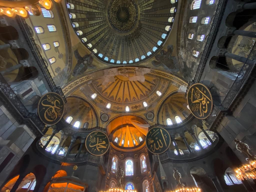 “Interior view of Hagia Sophia’s dome showcasing detailed Arabic calligraphy and ornate architectural patterns.”