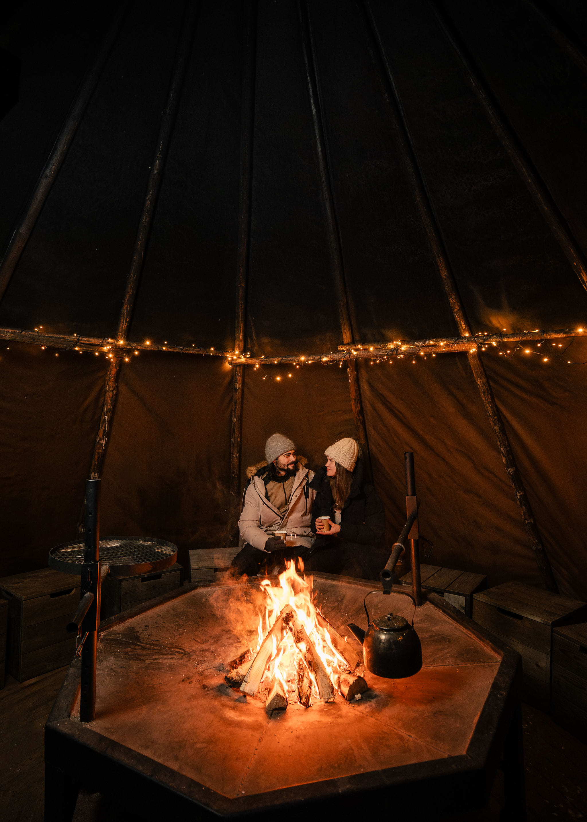A couple enjoying hot chocolate by the fire after the experience