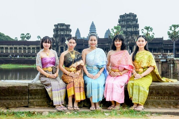 Traveler wearing traditional Khmer dress in front of Angkor Wat during a cultural photo tour
