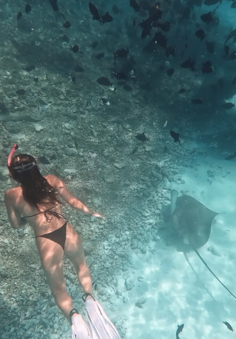 A girl snorkeling with stingrays in the clear waters of Kandu Oy Giri, North Male, during her stay at Noah Private Beach House