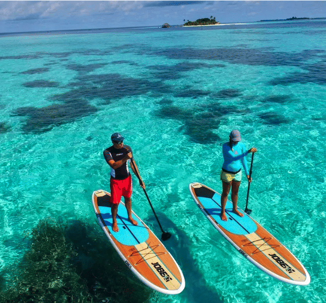 A kayak drone photo of a couple paddling in the Maldives waters