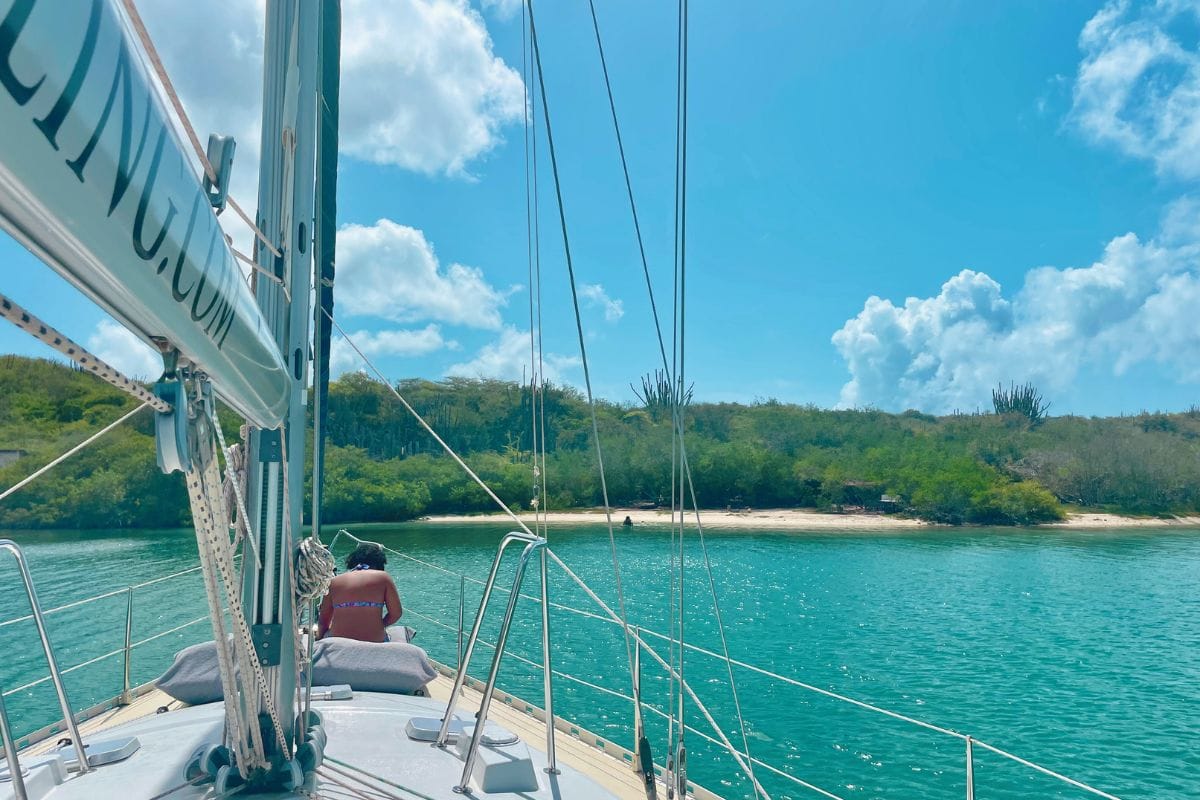 Beautiful woman erelaxing on front of yacht in Curacao on private tour Maxie Sailing