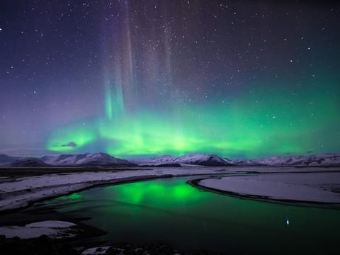 The spectacular show of the Northern Lights over a snow-covered Icelandic landscape