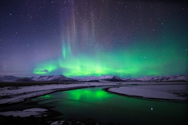 The spectacular show of the Northern Lights over a snow-covered Icelandic landscape