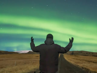 A man standing under the auroras in Iceland