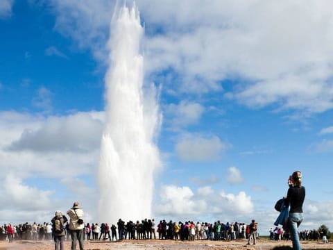 People overmatching Strokkur Geyser during South coast and northern lights tour