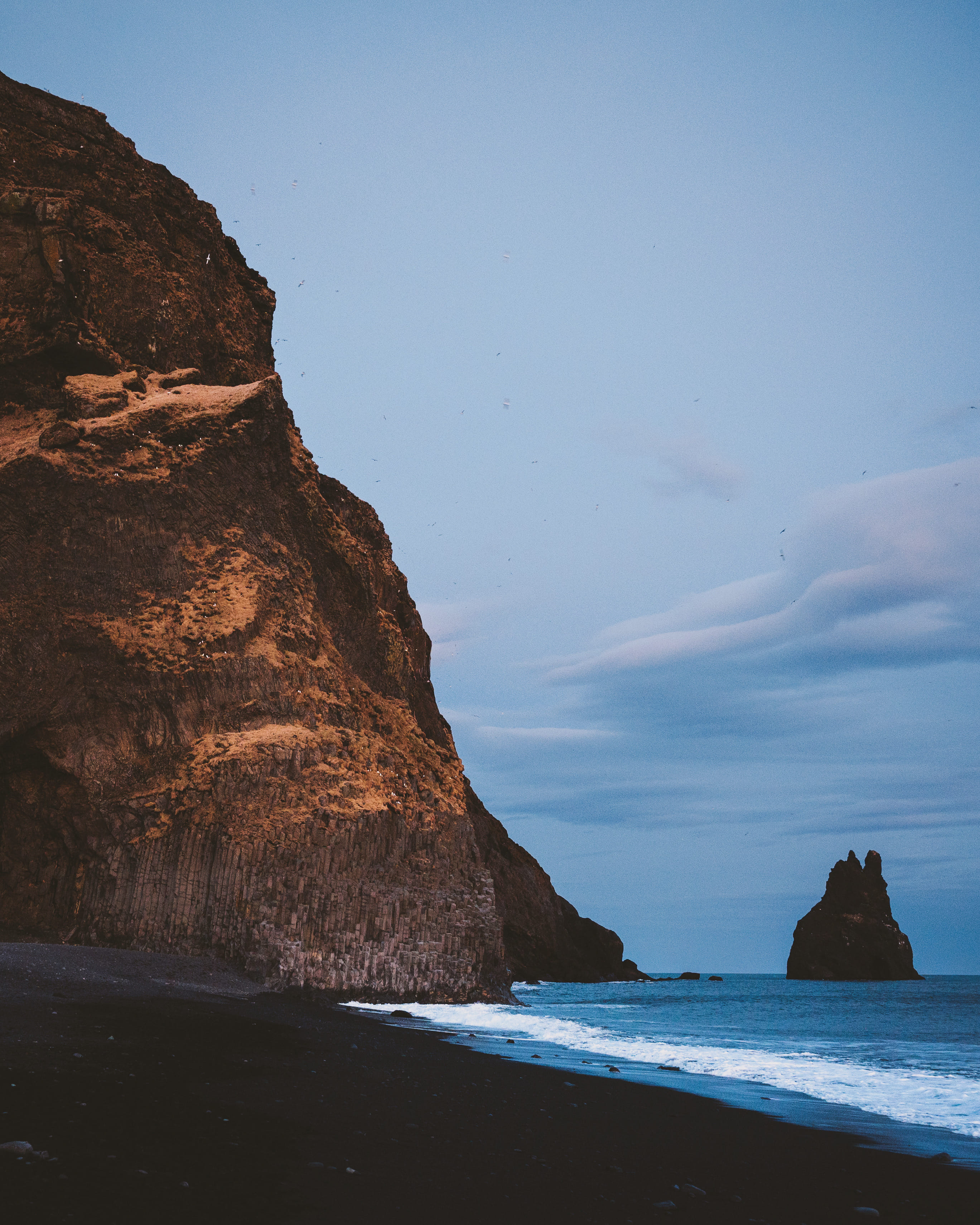Moody view of Reynisdrangar sea stacks from Reynisfjara black sand beach near Vík