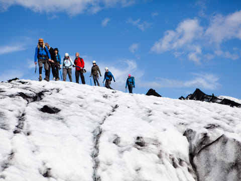 A small group of people exploring snowy glacier at Falljökull Glacier