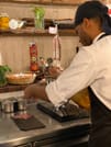The chef is slicing ham
