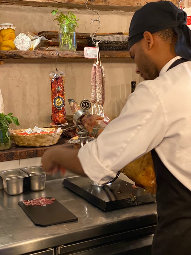 The chef is slicing ham