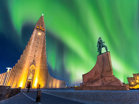 Northern lights dancing over Reykjavik with Hallgrimmskirkja pictured on the left side